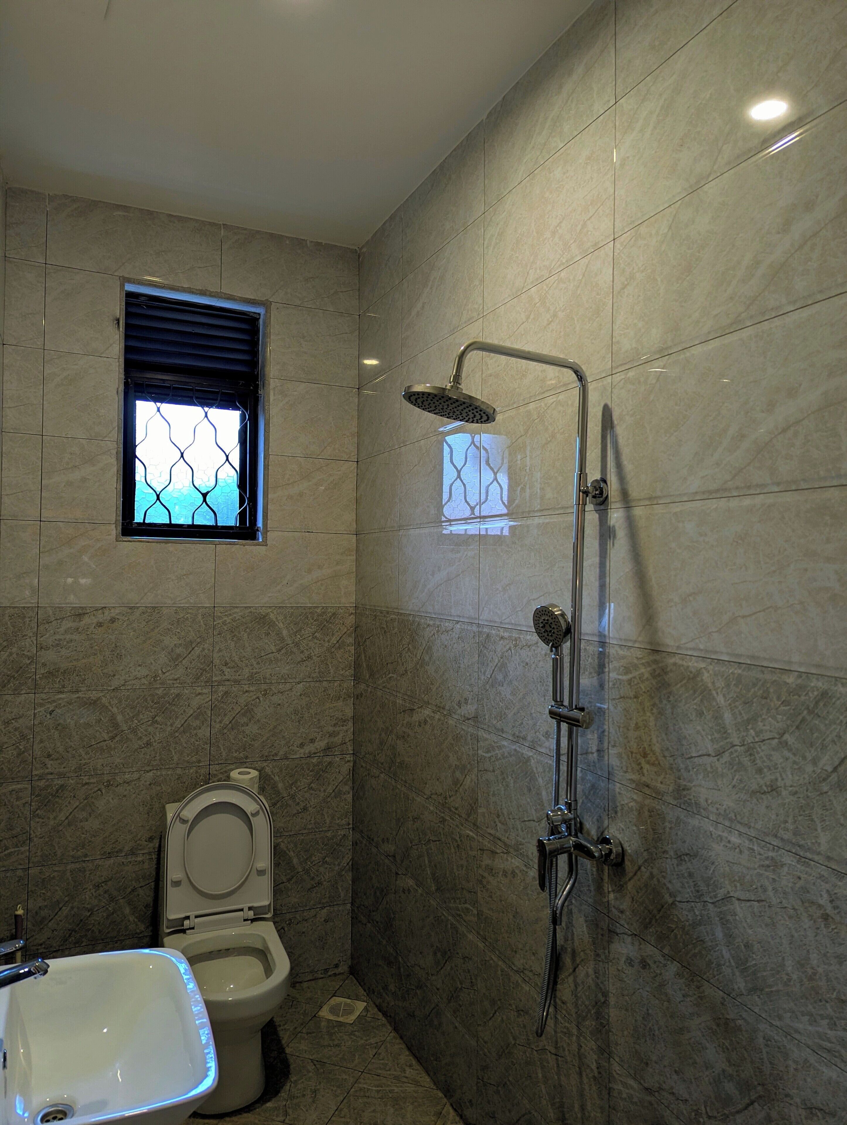 Un baño con ducha, inodoro y lavabo.