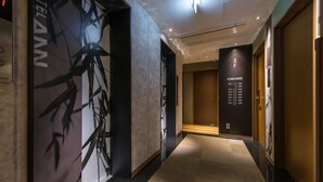 A hotel corridor with a bamboo-themed wall, a floor guide sign, and a carpeted floor. - Hotel Ann Asakusa (Tokyo)