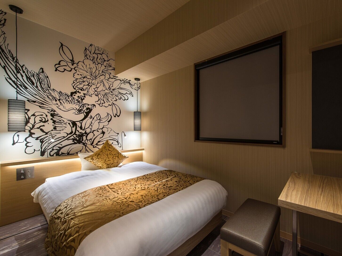 A hotel room with a large bed, a wall-mounted TV, a desk, and a decorative wall mural.