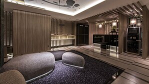 A modern interior with a seating area, a reception desk, and a TV screen. - Hotel Ann Asakusa (Tokyo)