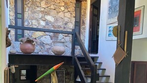 A stone wall with a rustic staircase, a birdhouse, and a decorative vase. - Beautiful and Comfortable House for up to 15 People in Arraial do Cabo (Location: Vacation Rental) (Arraial do Cabo)