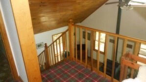 A wooden staircase with a plaid carpet, a ceiling fan, and a view of the outdoors. - Mountain views, total seclusion Southern Bedford County, PA - Big Discounts! (Clearville)