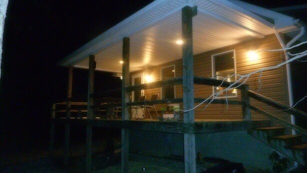 A wooden cabin with a covered porch and a staircase leading to the main floor. - Mountain views, total seclusion Southern Bedford County, PA - Big Discounts! (Clearville)