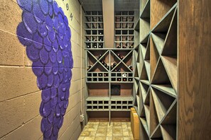 A wine cellar with wooden racks and a wall mural.