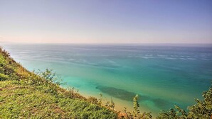 Eine Küstenlandschaft mit klarem türkisblauem Wasser und einer grasbewachsenen Uferlinie.