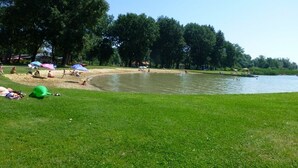 Un parc avec un lac, des pelouses et des arbres.