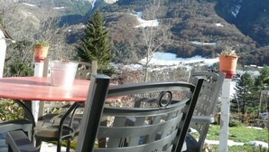 Une table et des chaises installées à l’extérieur, avec vue sur la montagne.