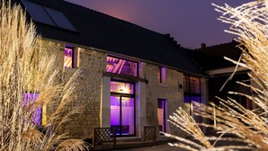 A stone building with a sloped roof, large windows, and a visible entrance. - 🌿 Chambres d'Hôtes Romance & PRIVATISED SPA : Intimate Luxury (Noyant-Et-Aconin)