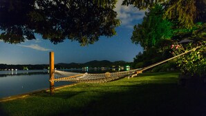A hammock by a lake at night with a clear sky and distant mountains. - The Heron House (Olympia)