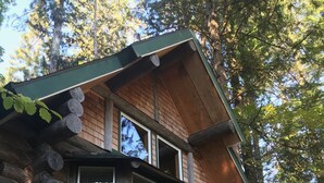 A log cabin with a balcony and a staircase leading to the entrance. - The Heron House (Olympia)