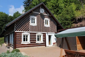 A wooden cabin with a sloped roof, two windows, and a satellite dish. - Lonely holiday house in protected area (Turnov)
