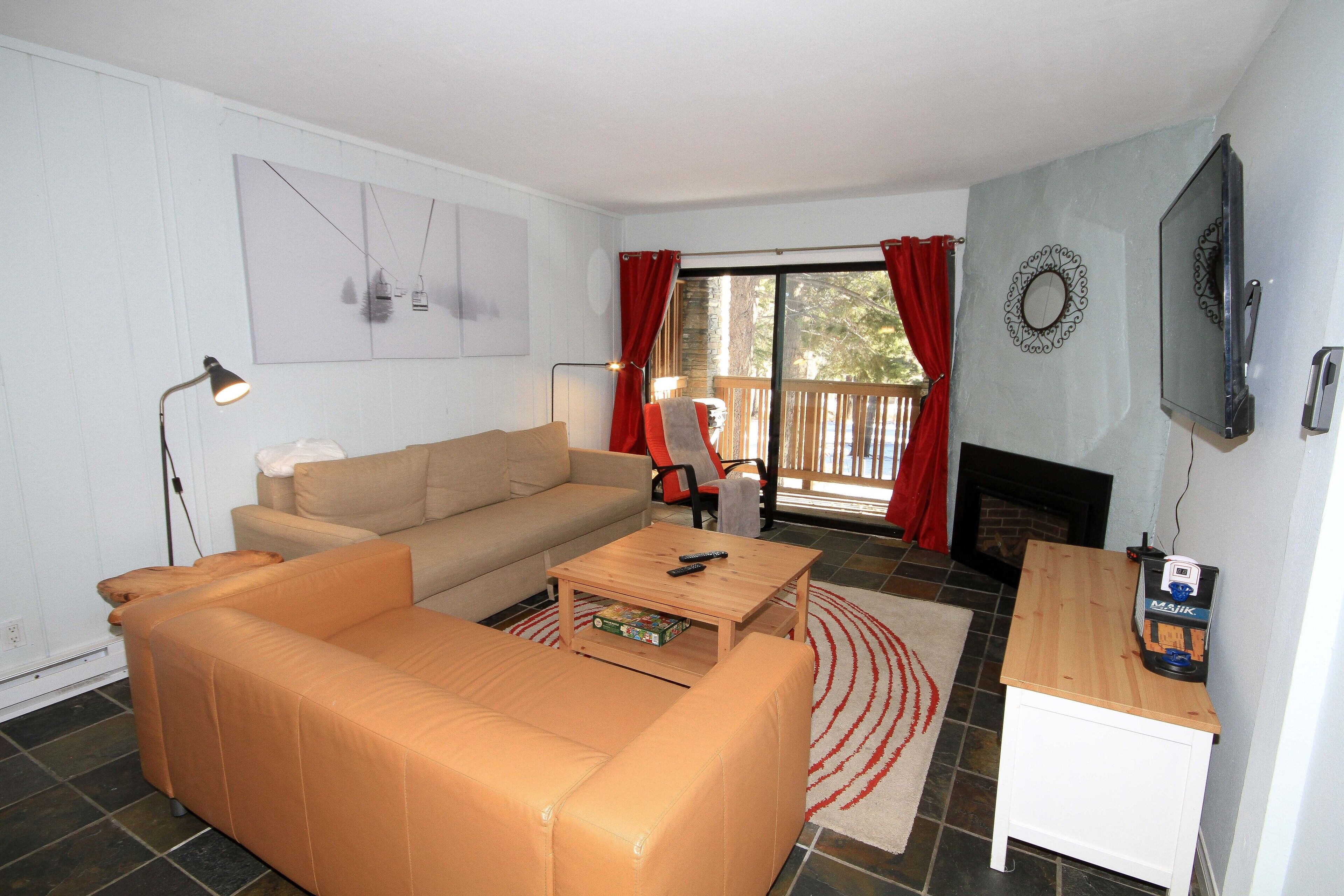 A living room with a sofa, coffee table, and a fireplace.