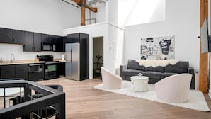 Un apartamento moderno con cocina, sala de estar y un amplio ventanal.