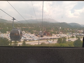 Una estación de teleférico con vistas a un pueblo y montañas al fondo.