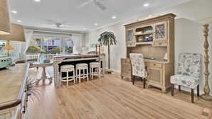 A spacious kitchen with a bar area, wooden cabinets, and a dining set. - Award-Winning Resort Amenities | Racquet Club Villa 6 (Isle of Palms)