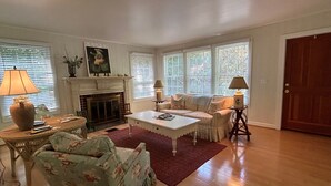 Un salon avec une cheminée, un canapé, une table basse et une lampe.