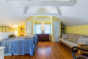 Une chambre à coucher avec un lit, une commode et un canapé.