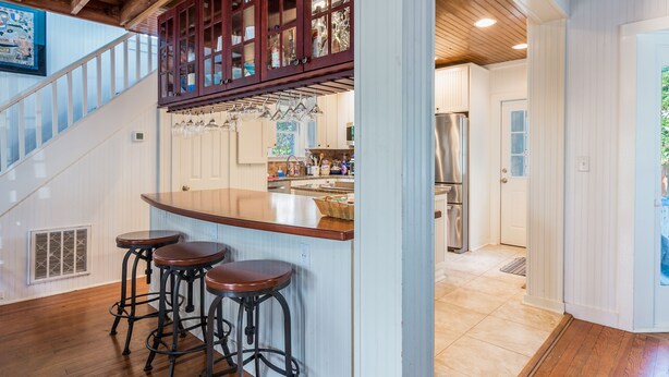 A kitchen with a wooden island, bar stools, and a stainless steel refrigerator. - Beach Block Living in Charming South Rehoboth. (Rehoboth Beach)