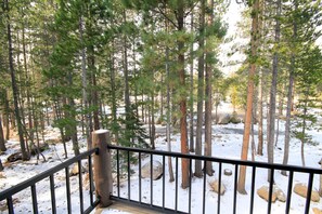 A forested area with a wooden railing, snow-covered ground, and trees. - Forest Creek #3, Pet accepted (Mammoth Lakes)