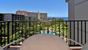 Ein Balkon mit Blick auf ein Resort, inklusive Pool und Palmen.