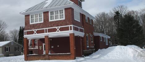 A two-story brick house with a covered porch and a garage.