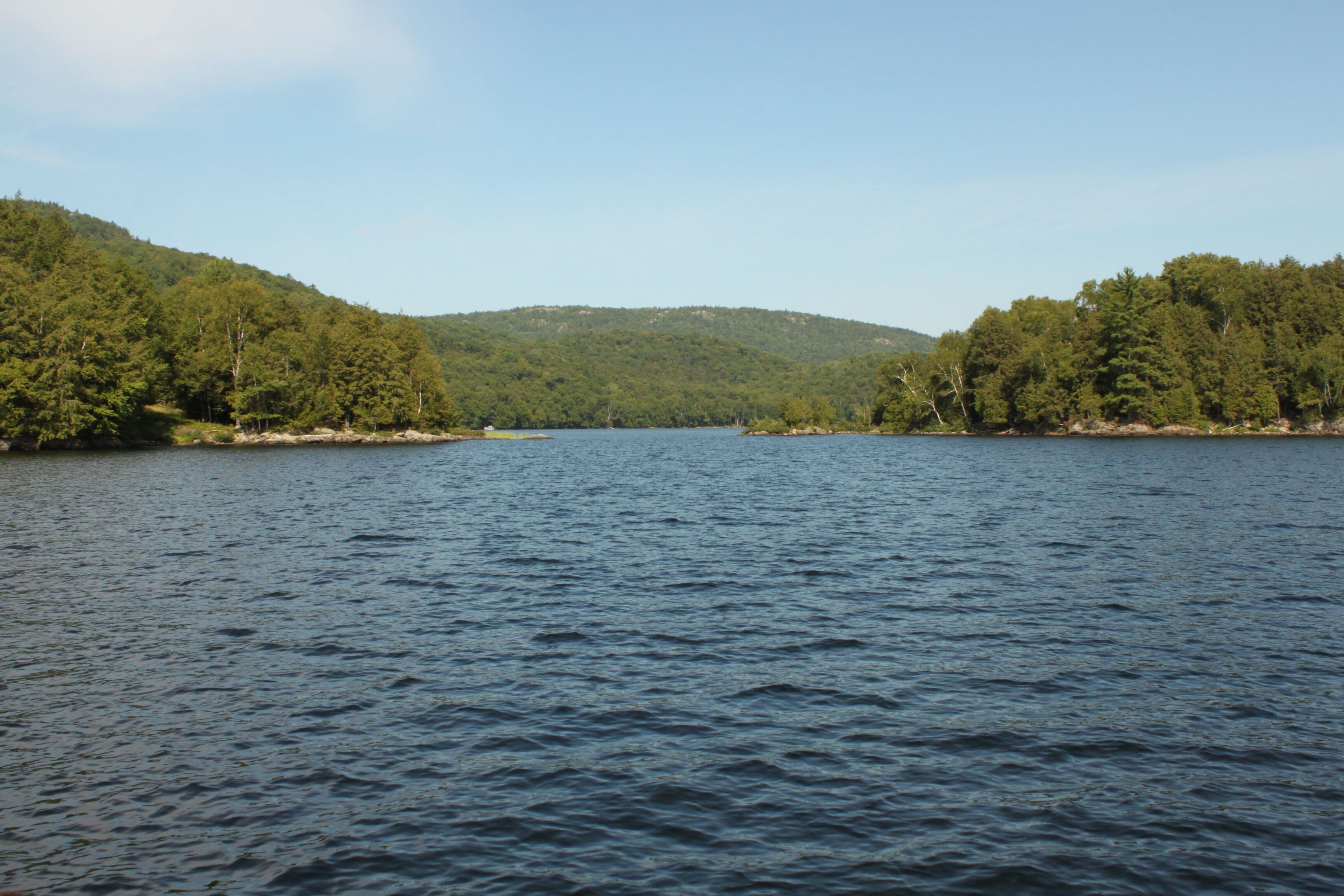 A lake surrounded by forested hills.