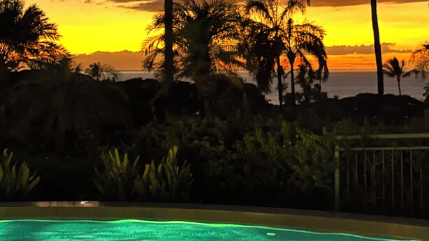 Tramonto con palme e piscina.