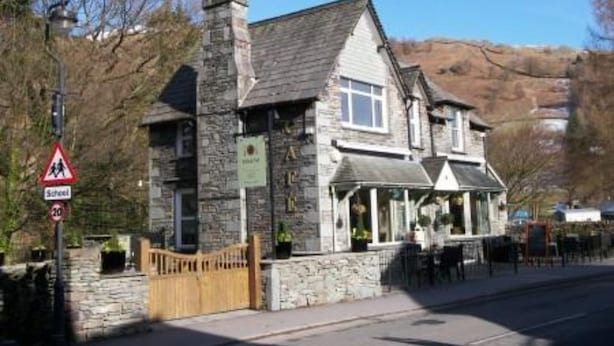 A stone building with a pub sign, a school crossing sign, and a speed limit sign. - Rothay Villa (Ambleside)