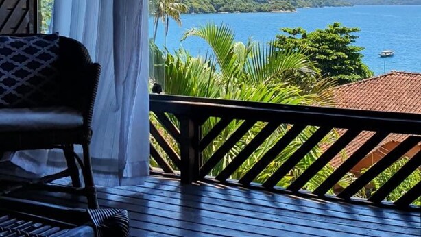 A wooden deck with a view of a lake and mountains. - Pousada Três Coqueiros (Angra dos Reis)