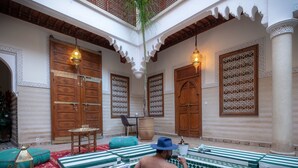 A traditional Moroccan courtyard with wooden doors, patterned windows, and a tiled swimming pool area. - Riad Ali Baba (Marrakech)