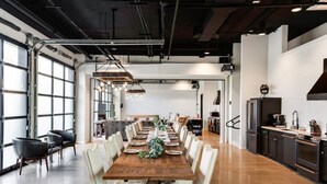 A spacious dining area with a long wooden table set for a meal, surrounded by chairs. - Inn Cahoots on 6th: 10BR/26Bed - Pool,Roofdeck, Garden Bars, Walk To Everything! (Austin)