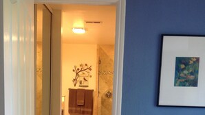 Une salle de bain avec une douche, un porte-serviettes et un tableau encadré au mur.