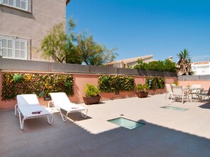 A rooftop terrace with lounge chairs, a table, and potted plants. - Bohemi, luxury seafront villa (Santa Margalida - Can Picafort/Son Serra Marina)