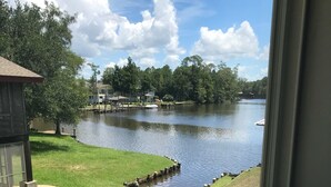 Vista de un lago con una zona de césped y un muelle.
