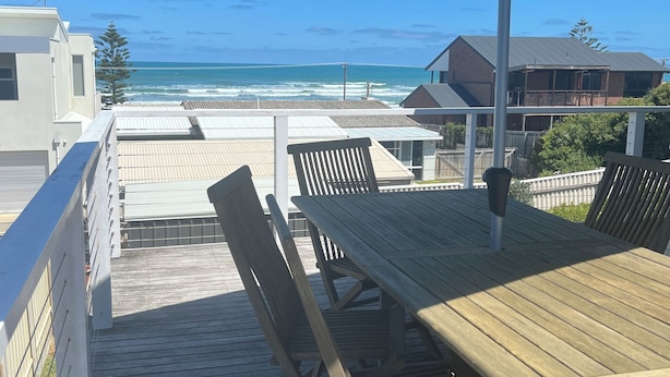 A wooden deck with a table and chairs, overlooking a beach. - Sable Blanc on Newell - dogs allowed - 3 min walk to the beach & fabulous views. (Middleton)