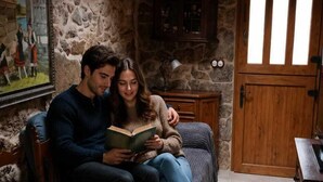 A rustic room with stone walls, a wooden door, a clock, and a painting. - Stone Cottage The Compostelana (Curtis)
