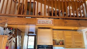 A wooden staircase leading to a second floor with a view of a kitchen area below. - La Tournette apartment Les Maisons des Bois (Manigod)