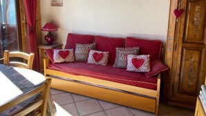 A cozy room with a wooden sofa, a small table, and a cabinet. - La Tournette apartment Les Maisons des Bois (Manigod)