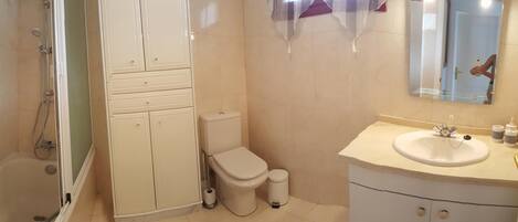 A bathroom with a shower, toilet, and sink.