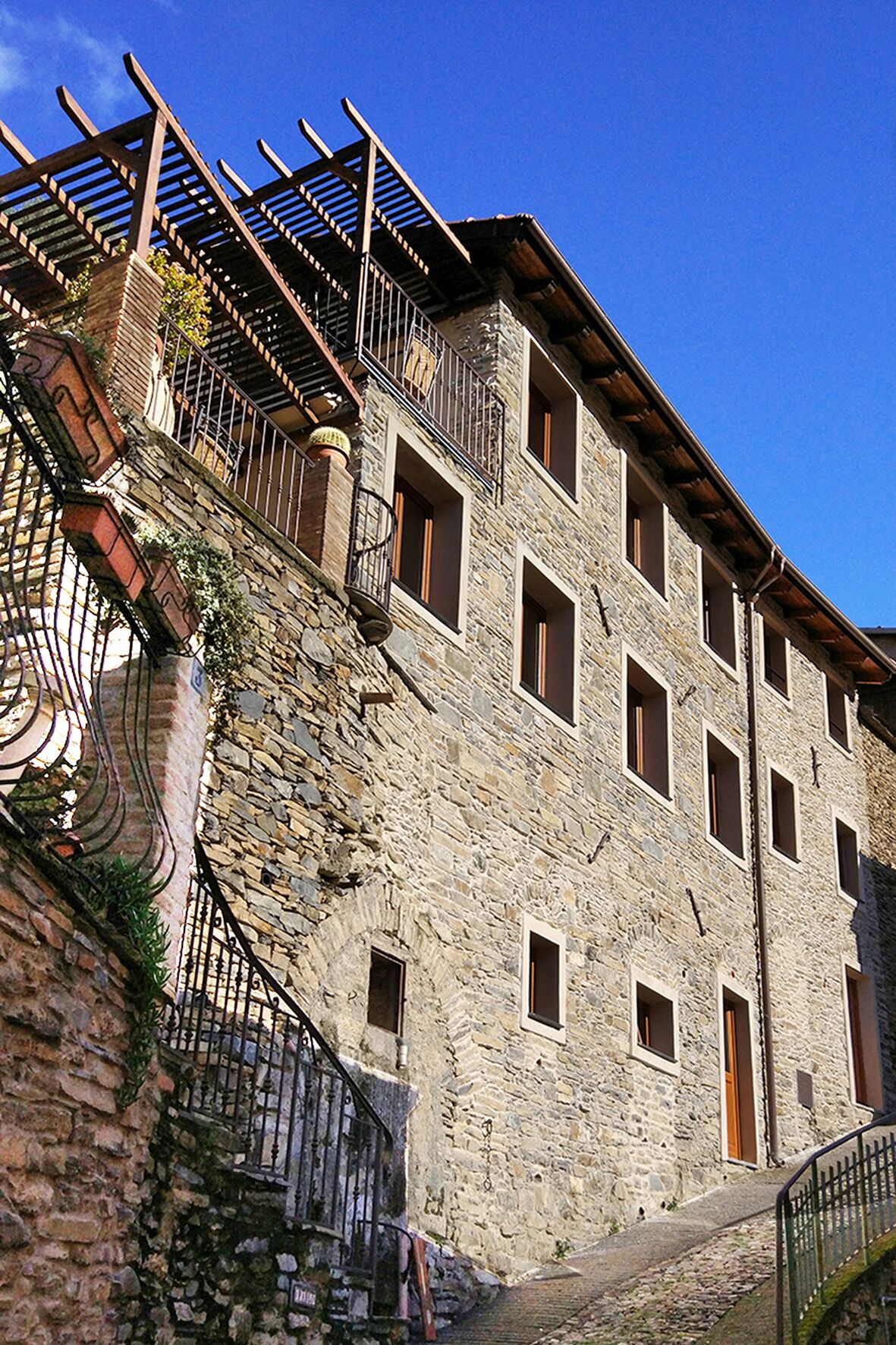 Un edificio in pietra con diverse finestre e una scala in legno.