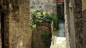 A narrow alleyway with stone walls, a mural, and a small garden area. - XVII SEC.  WINE CELLAR, FULLY RENOVATED, WITH SHARED TERRACE AND POOL (Badalucco)