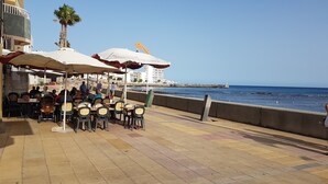 Ein Küsten-Café mit Außenbestuhlung und Meerblick.