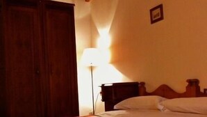Ein Hotelzimmer mit einem Bett, einem Holzschrank und einem Nachttisch.