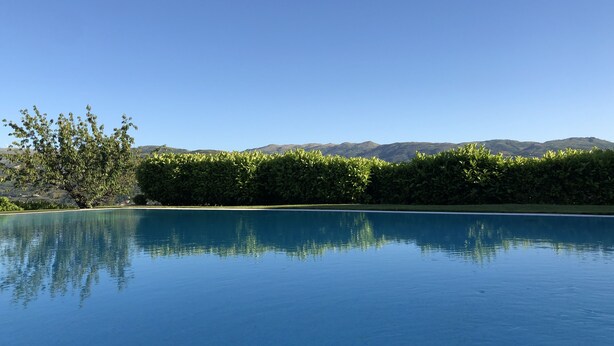 A clear blue pool reflecting trees and mountains in the background. - House of Steps - Santa Marinha do Zêzere (Baiao)