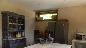 A kitchen with a marble island, wooden cabinets, a refrigerator, and a microwave. - House of Steps - Santa Marinha do Zêzere (Baiao)