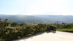 A paved pathway with a metal railing, overlooking a valley with mountains in the distance. - House of Steps - Santa Marinha do Zêzere (Baiao)
