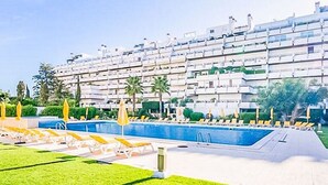 A hotel with a swimming pool, sun loungers, and a well-maintained lawn. - Luxury 3 Bedroomed Apartment- Stunning Views, Direct Marina Access & Shared Pool (Vilamoura)