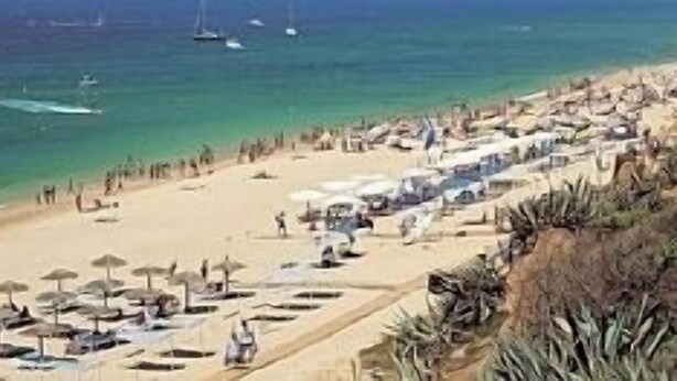 A beach with rows of umbrellas and sun loungers, a sandy shore, and boats in the water. - Luxury 3 Bedroomed Apartment- Stunning Views, Direct Marina Access & Shared Pool (Vilamoura)