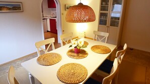 A dining area with a white table, woven placemats, and chairs with blue cushions. - Mediterranean flair above the rooftops of Cochem's old town (Cochem)