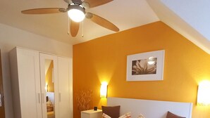 A hotel room with two beds, a ceiling fan, a bedside table with a lamp, and a framed picture on the wall. - Mediterranean flair above the rooftops of Cochem's old town (Cochem)